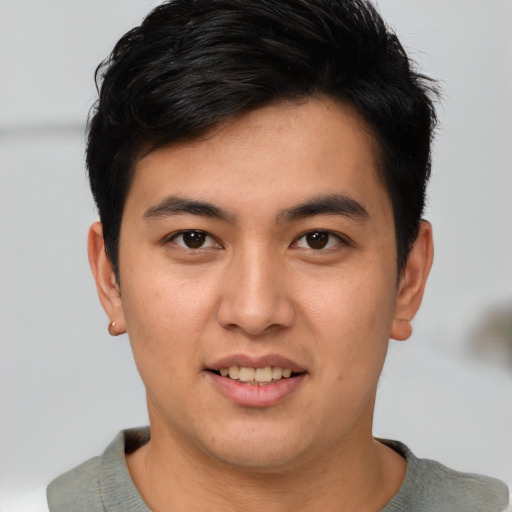 Joyful asian young-adult male with short  brown hair and brown eyes