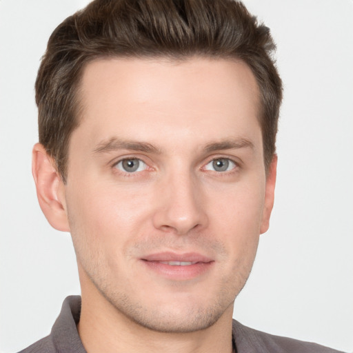 Joyful white young-adult male with short  brown hair and grey eyes