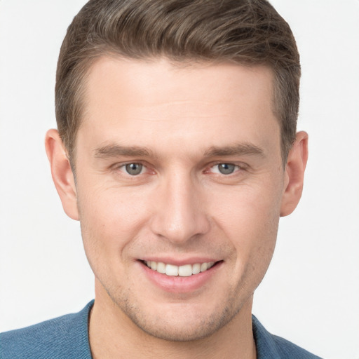 Joyful white young-adult male with short  brown hair and grey eyes