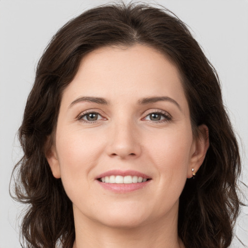 Joyful white young-adult female with long  brown hair and grey eyes