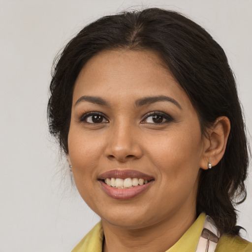 Joyful latino young-adult female with medium  brown hair and brown eyes