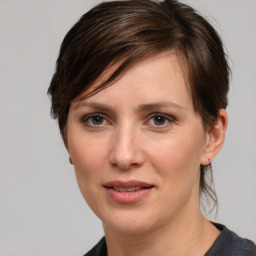 Joyful white young-adult female with medium  brown hair and grey eyes