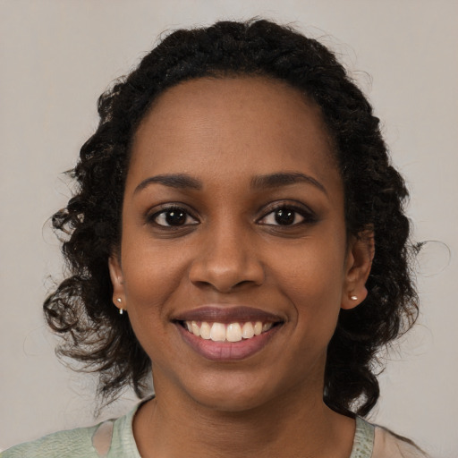 Joyful black young-adult female with medium  black hair and brown eyes
