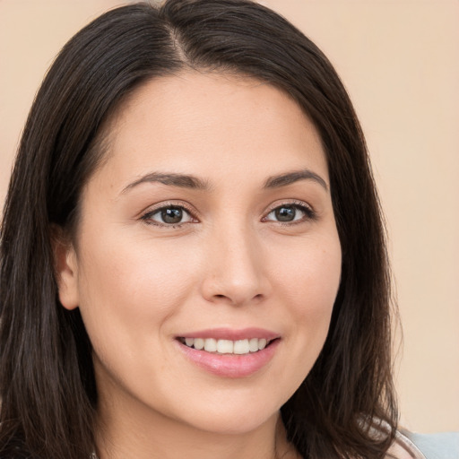 Joyful white young-adult female with long  brown hair and brown eyes