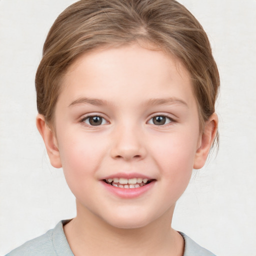 Joyful white child female with short  brown hair and blue eyes