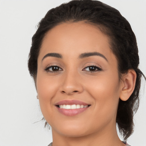 Joyful latino young-adult female with long  brown hair and brown eyes