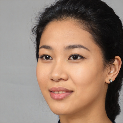 Joyful asian young-adult female with long  black hair and brown eyes