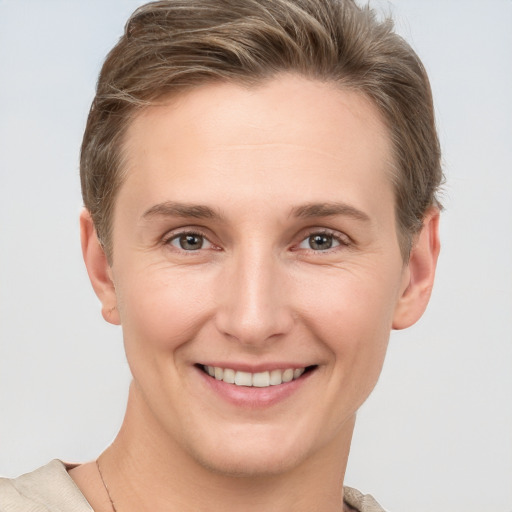 Joyful white young-adult female with short  brown hair and grey eyes