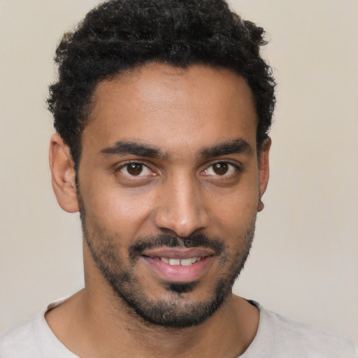 Joyful black young-adult male with short  black hair and brown eyes