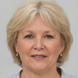 Joyful white middle-aged female with medium  blond hair and grey eyes