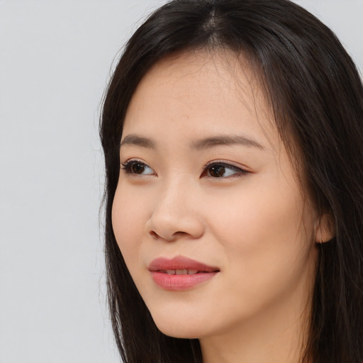 Joyful asian young-adult female with long  brown hair and brown eyes