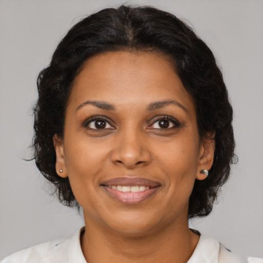 Joyful black adult female with medium  brown hair and brown eyes