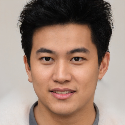 Joyful asian young-adult male with short  black hair and brown eyes