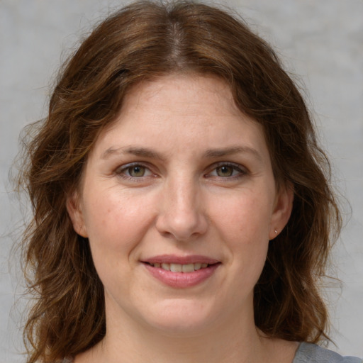 Joyful white young-adult female with medium  brown hair and green eyes