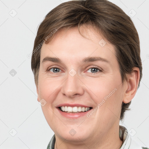 Joyful white young-adult female with medium  brown hair and grey eyes