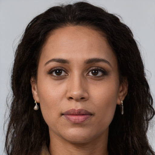 Joyful latino young-adult female with long  brown hair and brown eyes