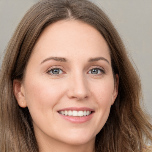 Joyful white young-adult female with long  brown hair and grey eyes