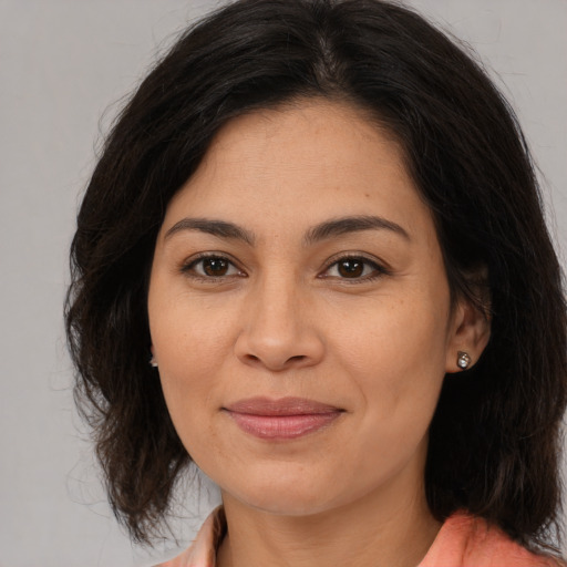 Joyful latino adult female with medium  brown hair and brown eyes