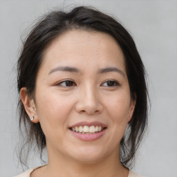 Joyful asian young-adult female with medium  brown hair and brown eyes