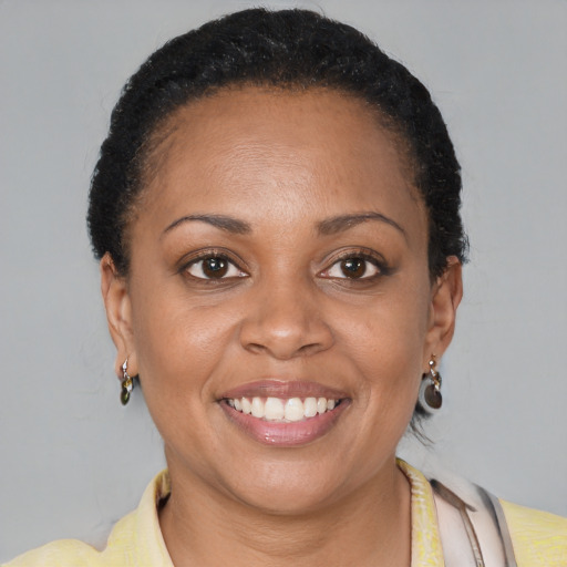 Joyful black adult female with short  brown hair and brown eyes