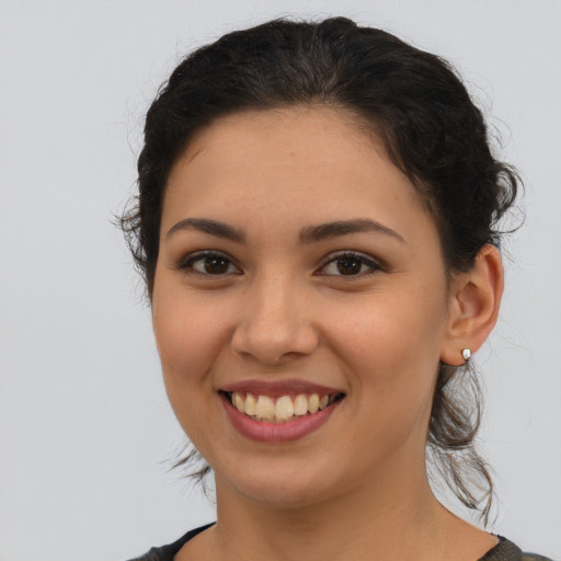 Joyful latino young-adult female with long  brown hair and brown eyes