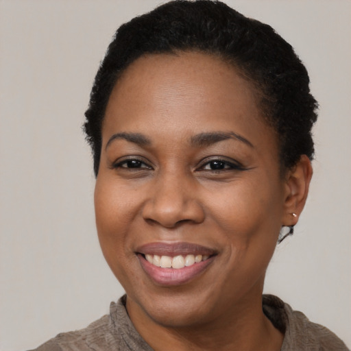 Joyful black adult female with short  black hair and brown eyes