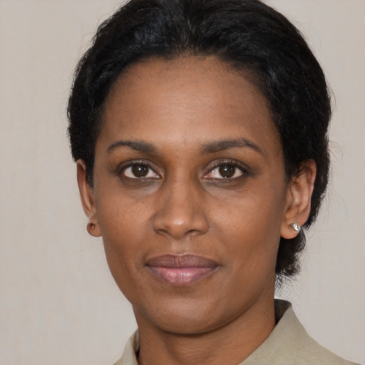 Joyful black adult female with short  black hair and brown eyes