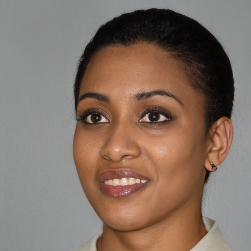 Joyful black young-adult female with short  black hair and brown eyes