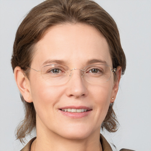 Joyful white adult female with medium  brown hair and grey eyes