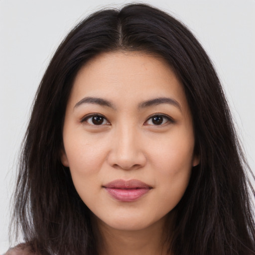 Joyful latino young-adult female with long  brown hair and brown eyes