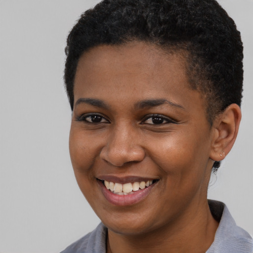 Joyful black young-adult female with short  black hair and brown eyes