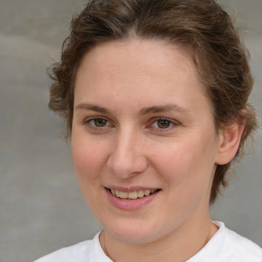 Joyful white young-adult female with medium  brown hair and green eyes