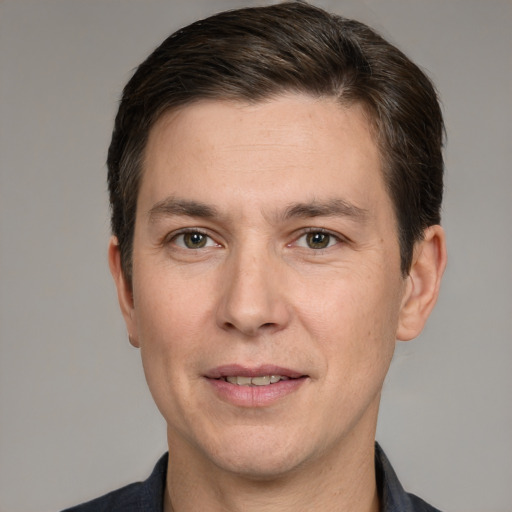 Joyful white adult male with short  brown hair and grey eyes