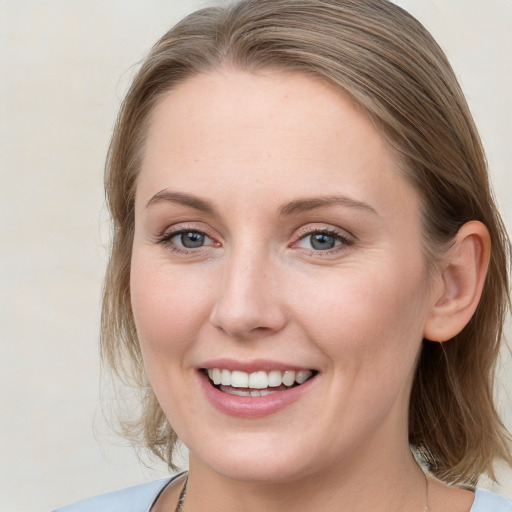 Joyful white young-adult female with medium  brown hair and blue eyes