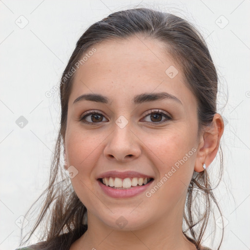 Joyful white young-adult female with long  brown hair and brown eyes