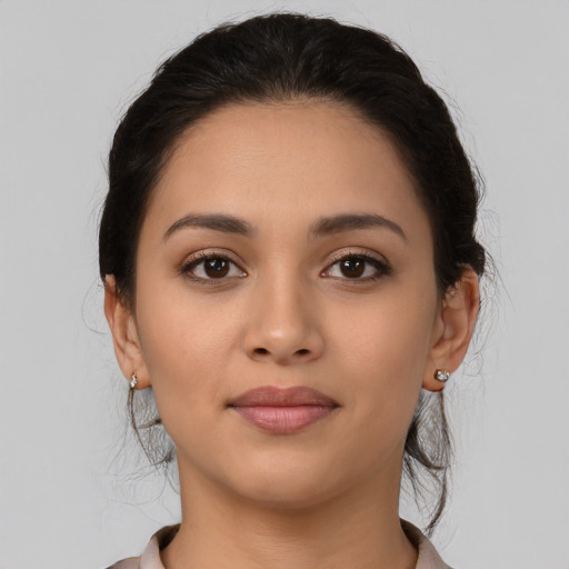 Joyful latino young-adult female with medium  brown hair and brown eyes