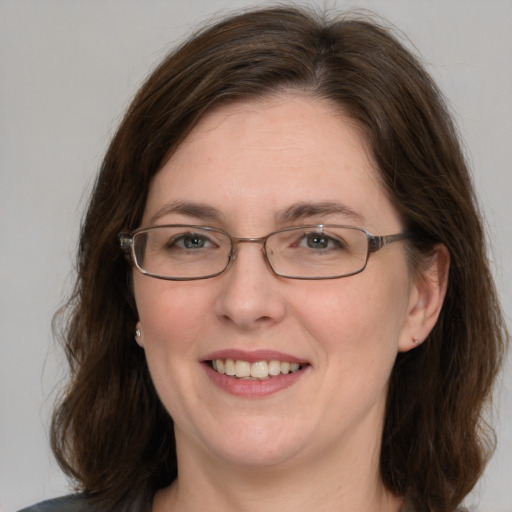 Joyful white adult female with medium  brown hair and grey eyes