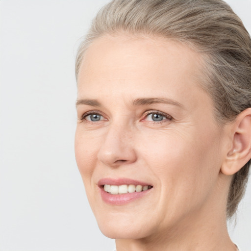 Joyful white young-adult female with medium  brown hair and blue eyes