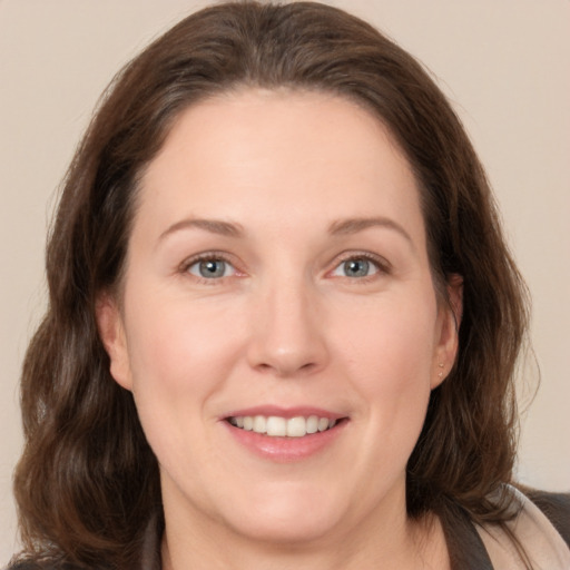 Joyful white adult female with medium  brown hair and brown eyes