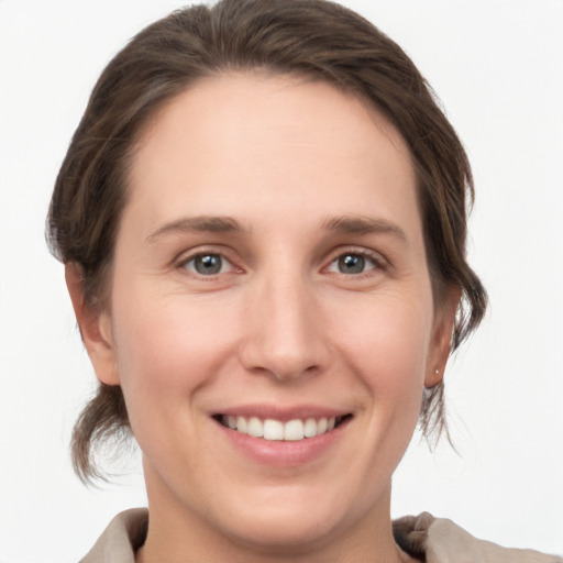 Joyful white young-adult female with medium  brown hair and grey eyes