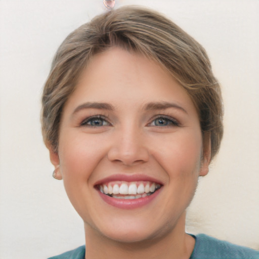 Joyful white young-adult female with medium  brown hair and grey eyes