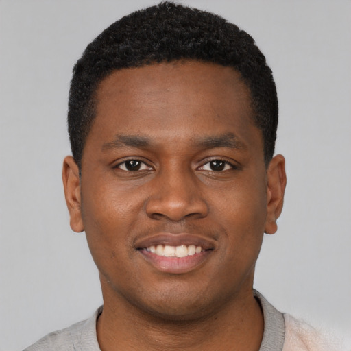 Joyful black young-adult male with short  black hair and brown eyes
