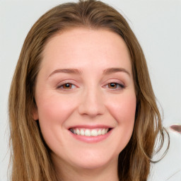 Joyful white young-adult female with long  brown hair and blue eyes