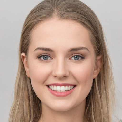 Joyful white young-adult female with long  brown hair and green eyes