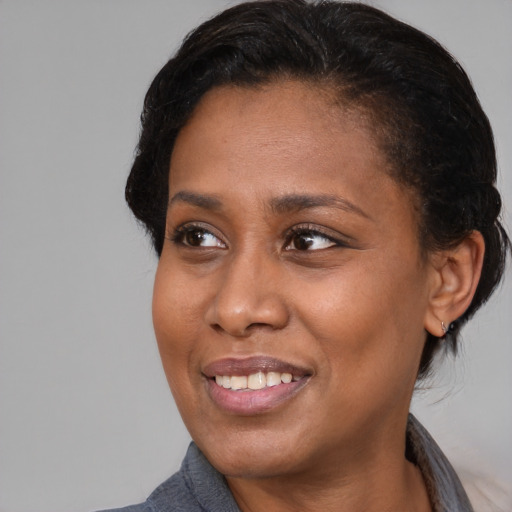 Joyful black adult female with medium  black hair and brown eyes