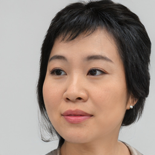 Joyful asian young-adult female with medium  black hair and brown eyes