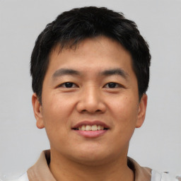 Joyful asian young-adult male with short  black hair and brown eyes