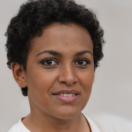 Joyful black young-adult female with short  brown hair and brown eyes
