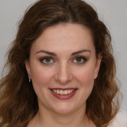 Joyful white young-adult female with medium  brown hair and green eyes