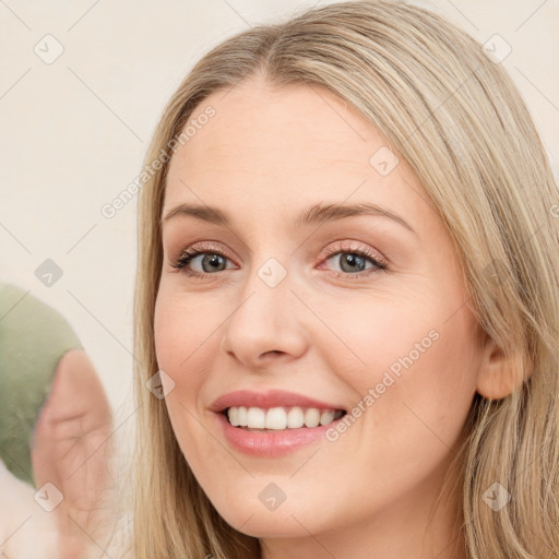 Joyful white young-adult female with long  brown hair and blue eyes